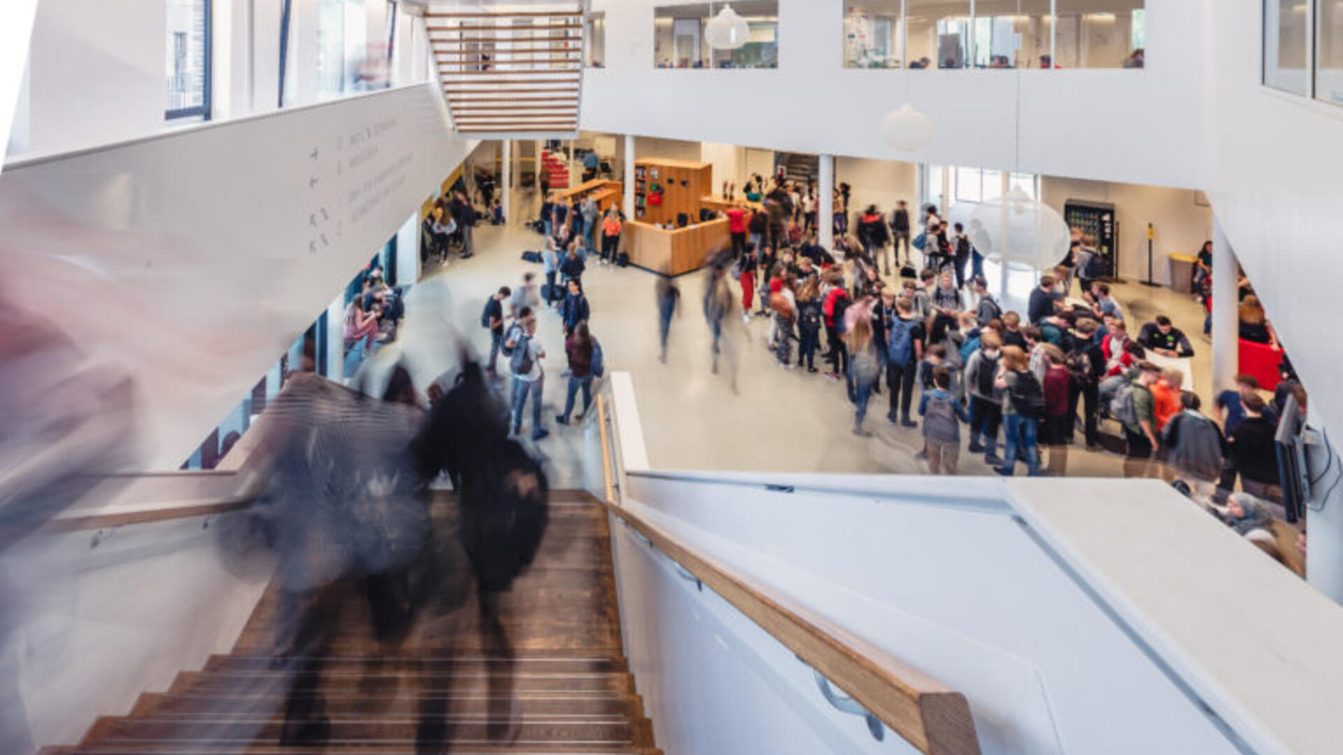 Binnenkant van een schoolgebouw, met leerlingen die van een trap aflopen